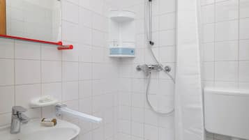 Un baño con lavamanos blanco, bañera, ducha e inodoro.
