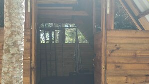 An open wooden door leading to a room with a wooden floor, a ladder, and a window. - cabaña con baño interno, en el balcón jacuzzi (Quebradanegra)
