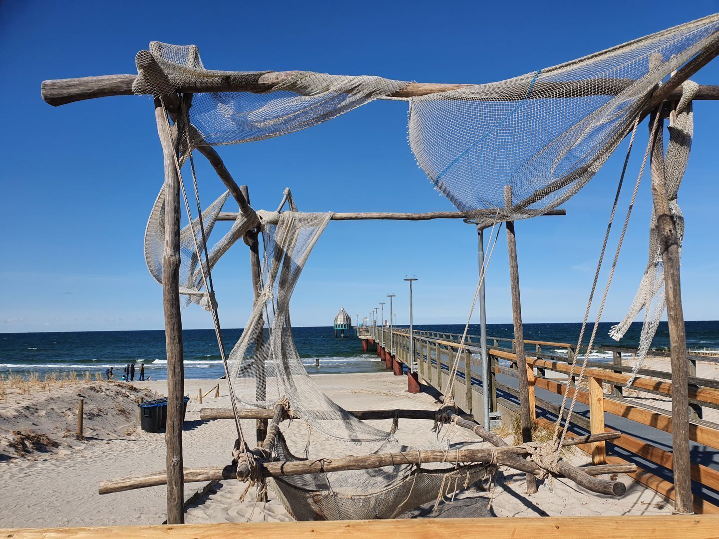 A beach with wooden structures and ropes, likely used for fishing.