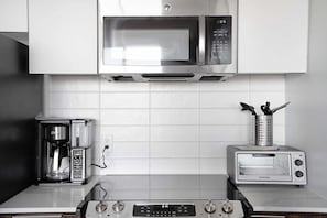 Eine Küche mit Mikrowelle, Kaffeemaschine, Toaster und Herd.