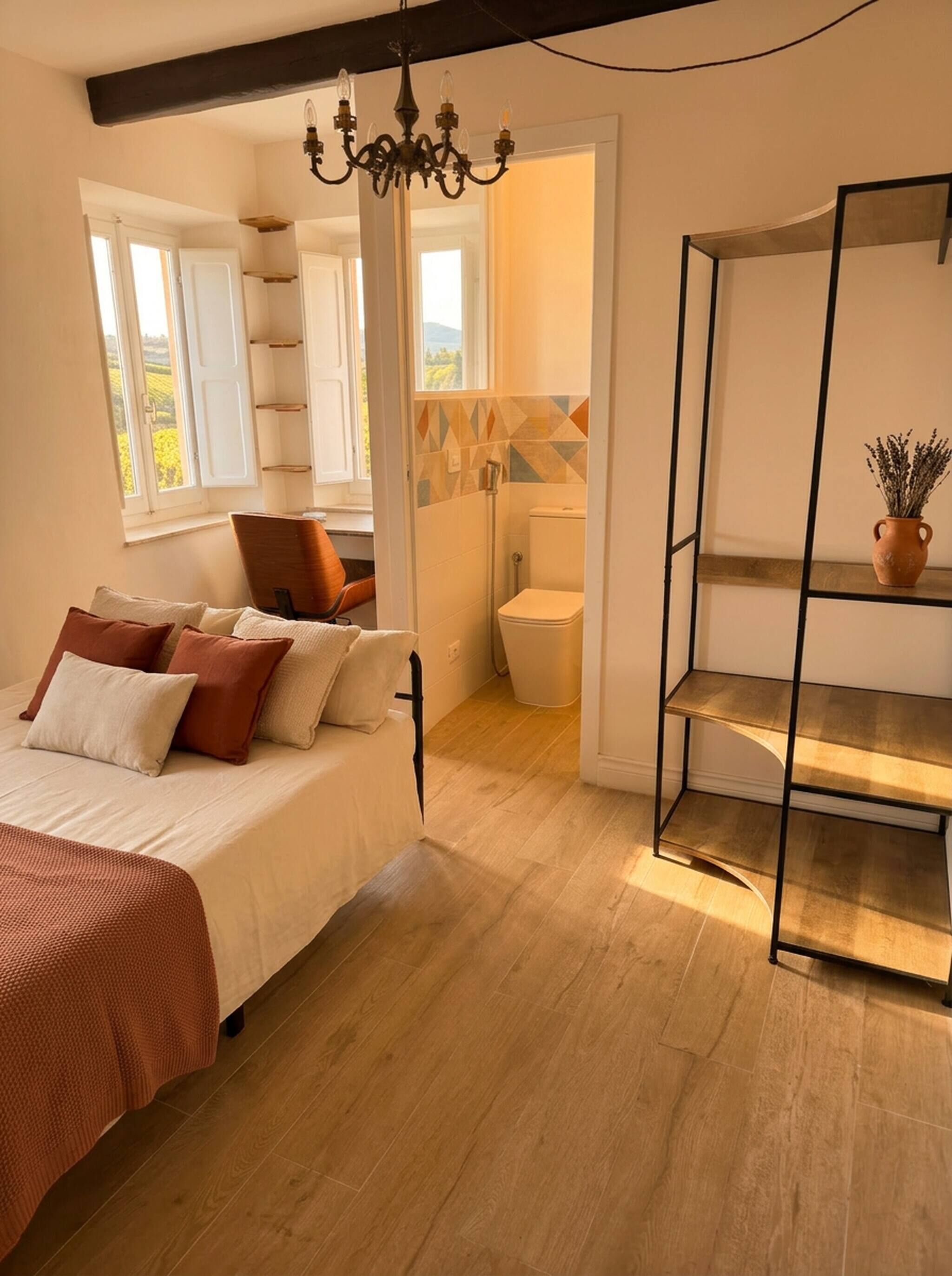 Ein Schlafzimmer mit Bett, Stuhl, Regal und Blick nach draußen.