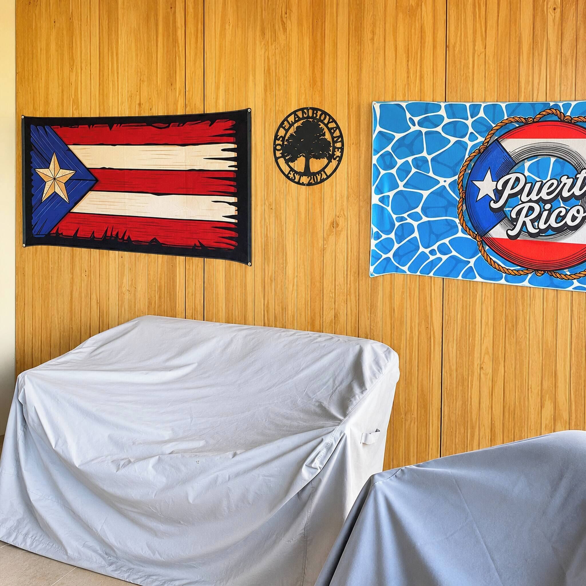 A room with a wooden wall, a covered table, and two wall decorations.