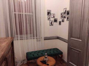 A room with a wooden bench, a small round table, and a door.