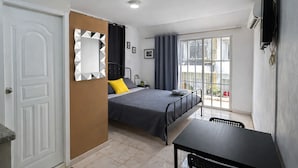 Une chambre à coucher avec un lit, une table, un miroir et une fenêtre.