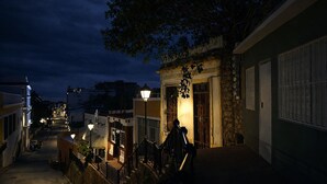 Une scène de rue nocturne avec des bâtiments, un vélo et un lampadaire.