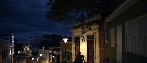 A nighttime street scene with buildings, a bicycle, and a street lamp.