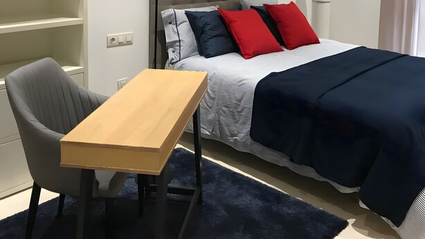 A hotel room with a bed, a desk, a chair, a lamp, and a wardrobe. - Seafront playa Patacona Mare Nostrum (Alboraya)