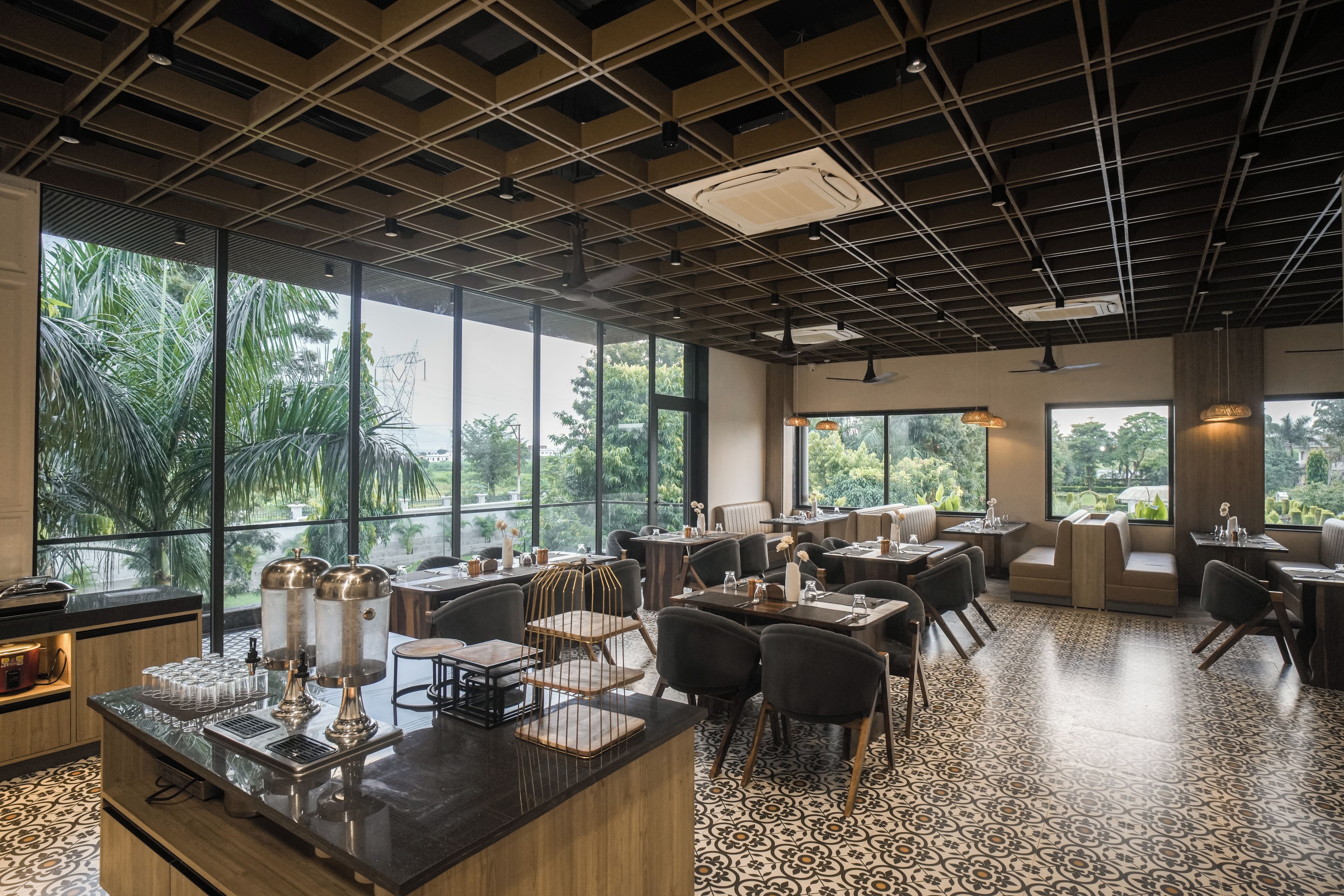 Ein Restaurant mit modernem Interieur, großen Fenstern und einem gemusterten Boden.