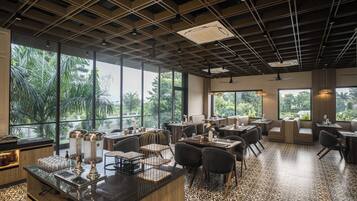 Ein Restaurant mit modernem Interieur, großen Fenstern und einem gemusterten Boden.