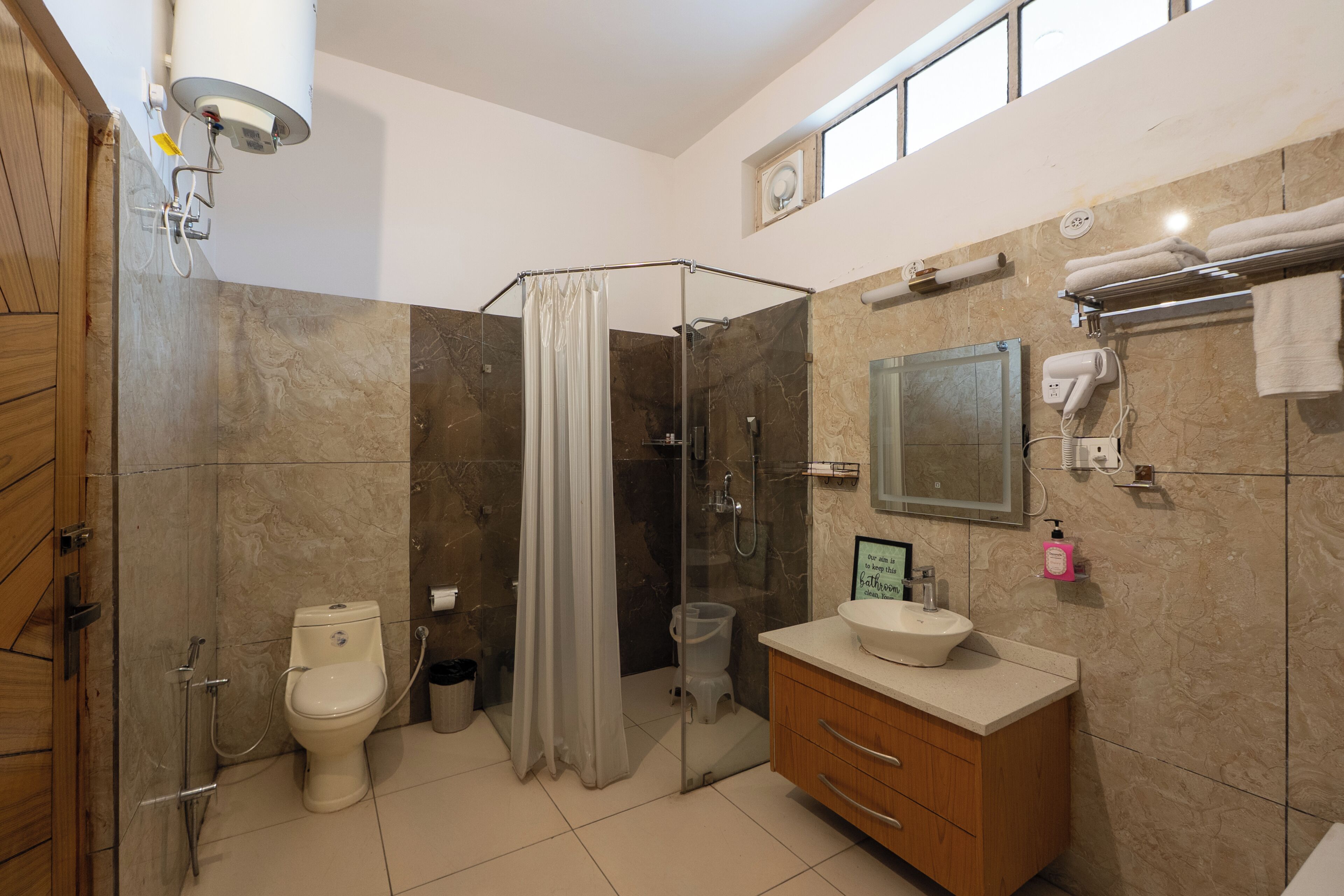 A modern bathroom with a glass shower enclosure, a toilet, a vanity with a sink, and a towel rack.