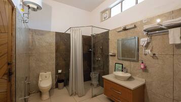 A modern bathroom with a glass shower enclosure, a toilet, a vanity with a sink, and a towel rack.
