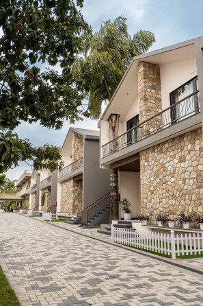 A row of modern buildings with stone facades and balconies. - juSTa Nature's Nest Resort (Rishikesh)