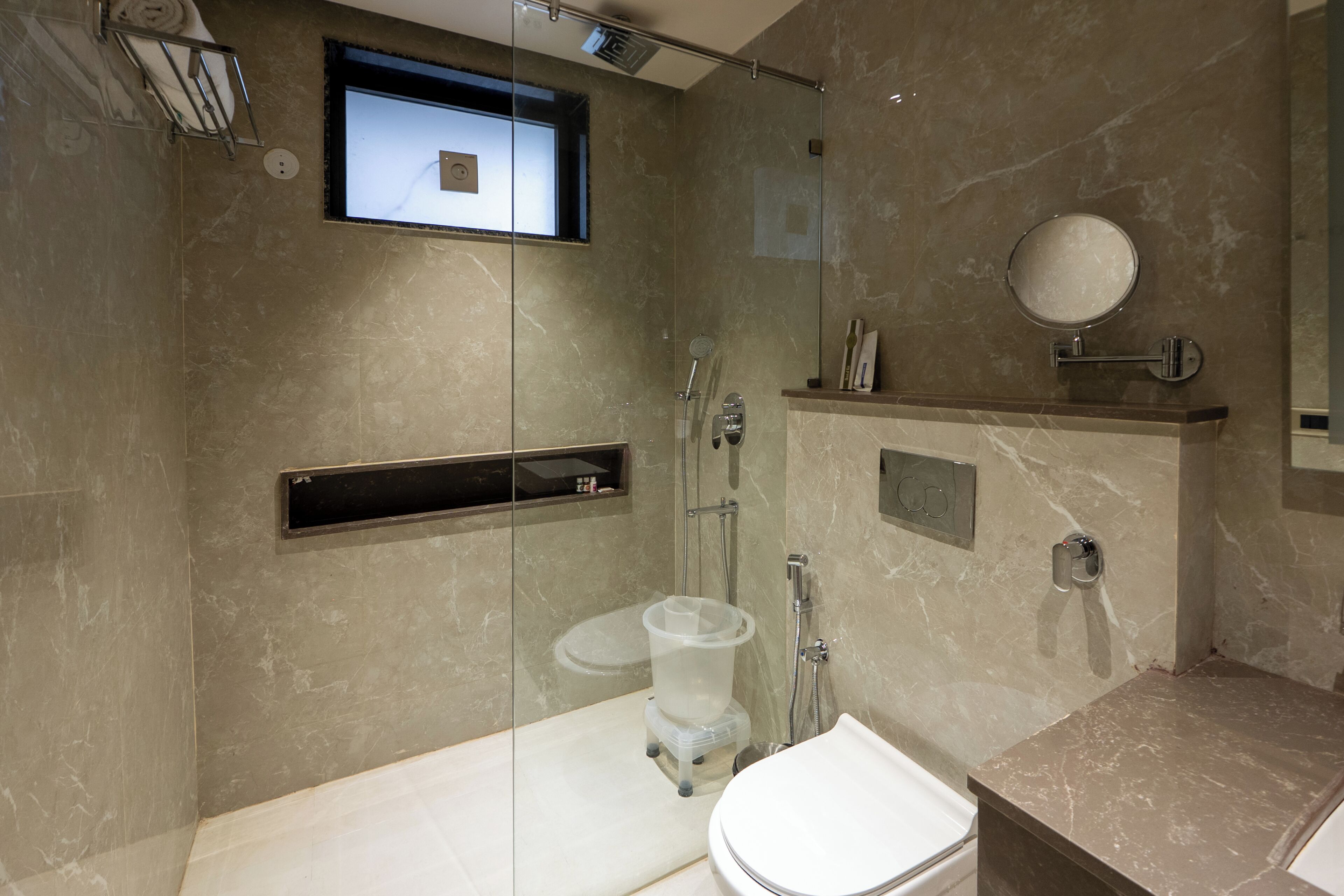 Un baño moderno con cabina de ducha de vidrio, inodoro y lavamanos.