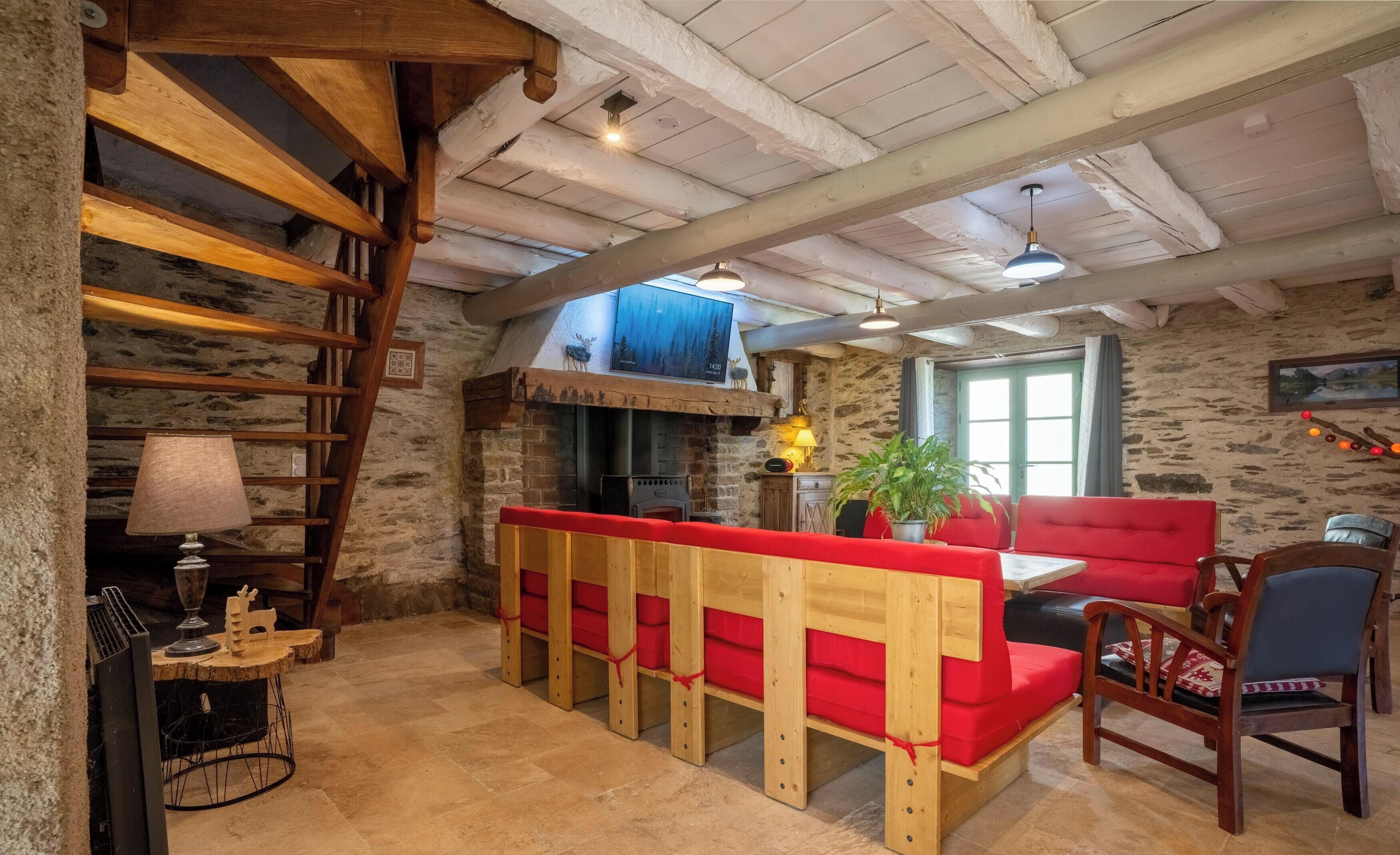 Un intérieur rustique avec un banc en bois, des murs en pierre et une cheminée.