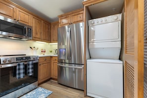 A kitchen with stainless steel appliances, wooden cabinets, and a built-in oven. - Steps from Slopes | Winter Shuttle | Pool & Hot Tub (Steamboat Springs)