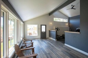 Une pièce spacieuse avec un long banc, un bureau équipé d’un ordinateur et un ventilateur de plafond.