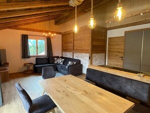 Een modern interieur met een houten plafond, een eettafel, een bank en een lange houten zitting.