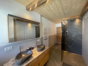A modern bathroom with a large mirror, a stone sink, and a walk-in shower. - Ferienwohnungen Unterdürmoos Apartments mit Chalet-Charme auf 1050 m, Alleinlage (Promberg)