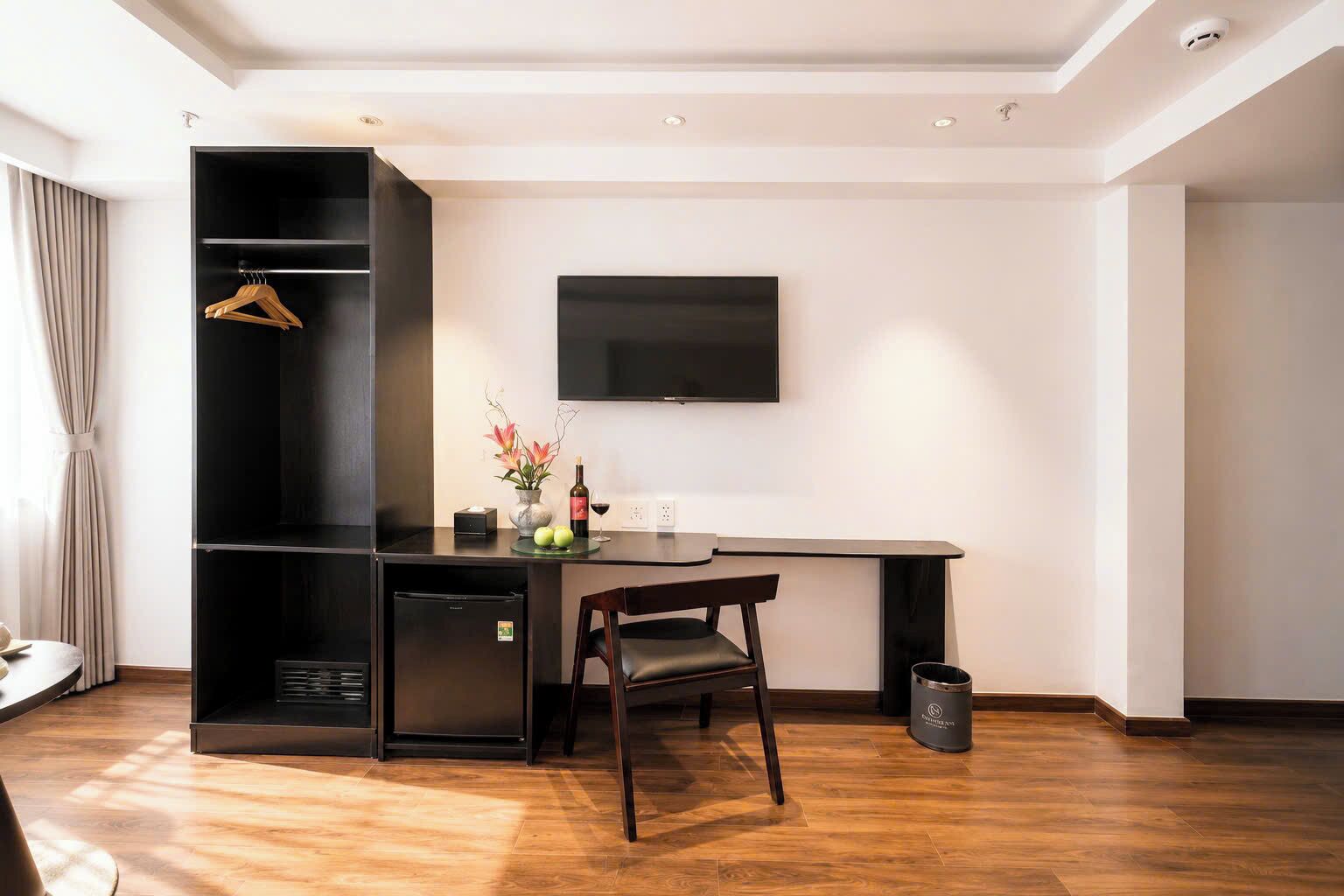 A modern room with a desk, chair, and a television mounted on the wall.