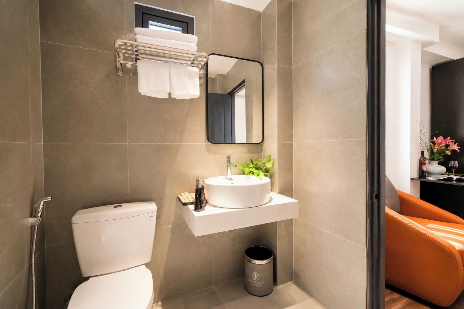 A modern bathroom with a toilet, sink, and mirror.
