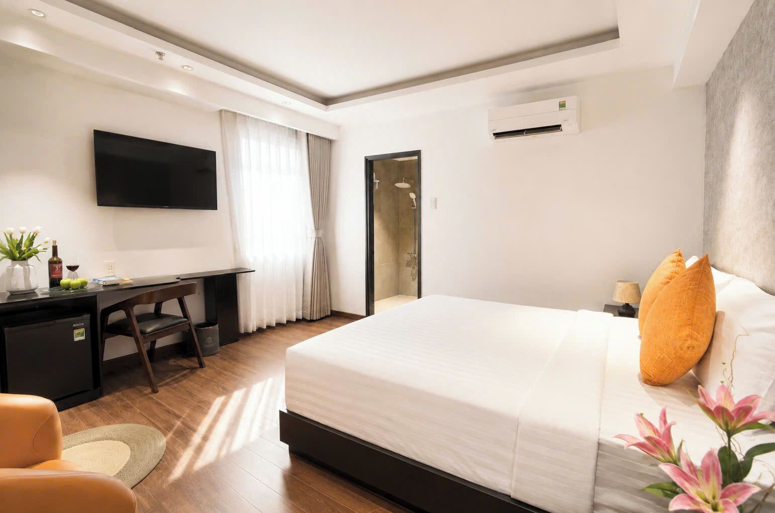Une chambre d’hôtel équipée d’un lit, d’un bureau, d’une télévision et d’un climatiseur.