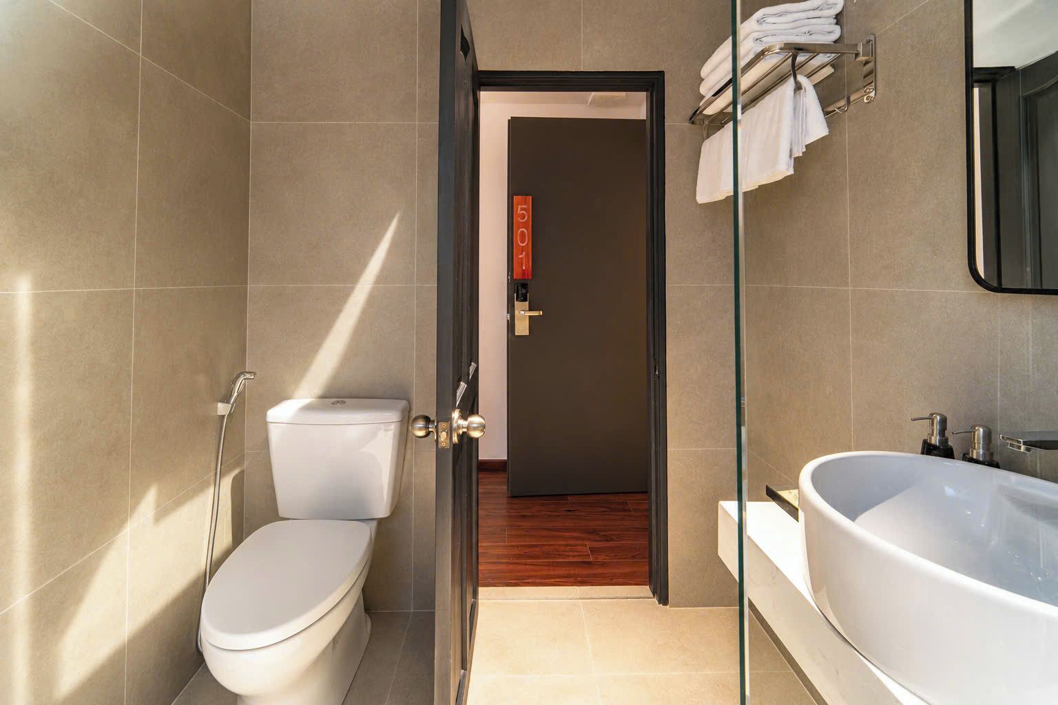 Une salle de bain moderne équipée de toilettes, d’un bidet et d’une grande baignoire.