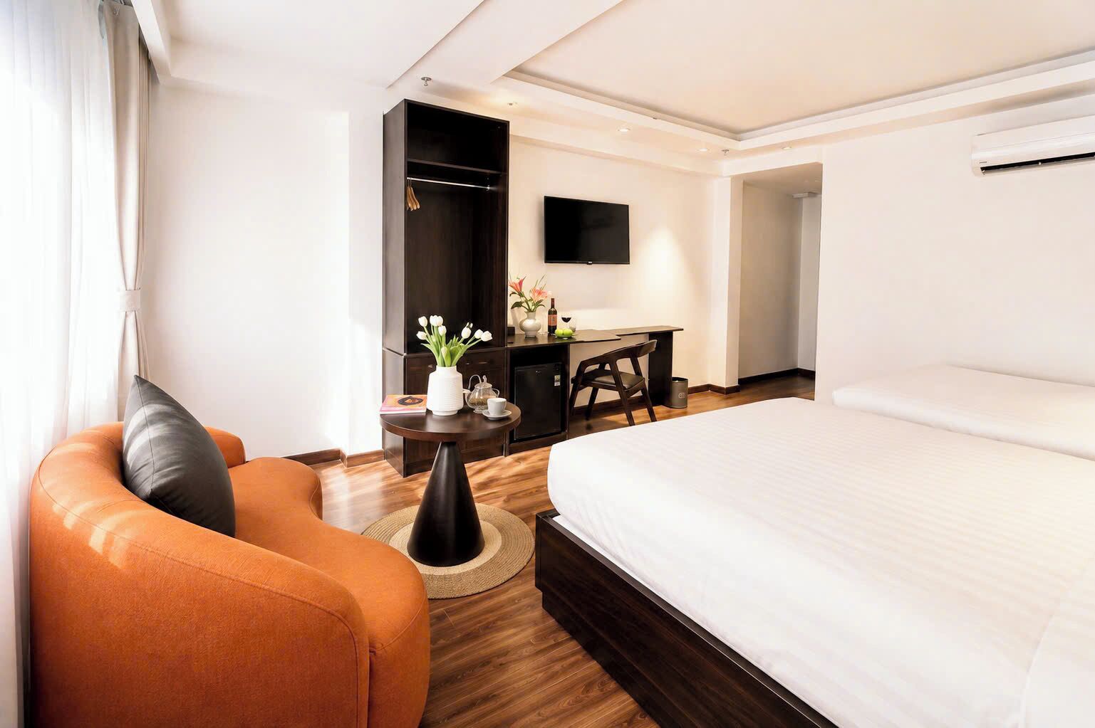 Une chambre d’hôtel équipée d’un lit, d’un bureau, d’une chaise, d’une télévision et d’une armoire.