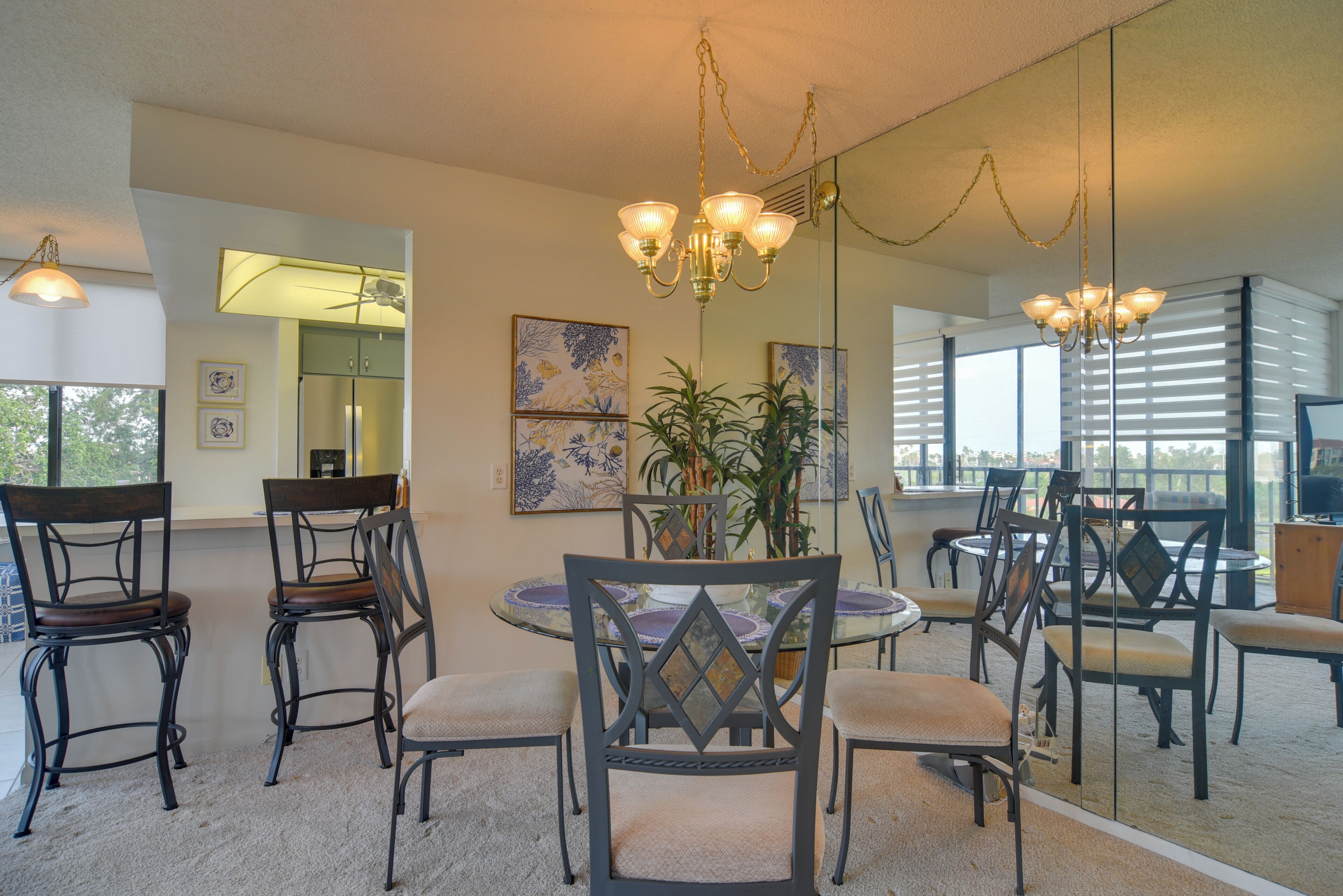 A dining area with a round table, chairs, and a chandelier.
