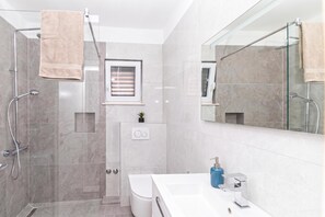 A modern bathroom with a glass shower enclosure, a white sink, and a large mirror. - Twin Apartments With BBQ Area (Okrug)