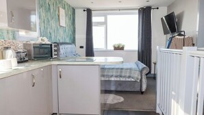 Eine kompakte Küche mit Toaster, Mikrowelle und einem kleinen Esstisch.