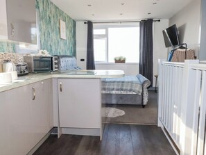 Eine kompakte Küche mit Toaster, Mikrowelle und einem kleinen Esstisch.