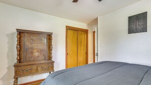 Quarto com uma cama grande, um armário de madeira e uma porta.
