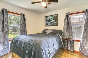 A bedroom with a bed, a ceiling fan, a painting, and curtains. - 4 Mi to Sabine River! Extended Escape w/ Yard (Orange)