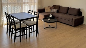En stue med spisebord, stole, sofa og sofabord.