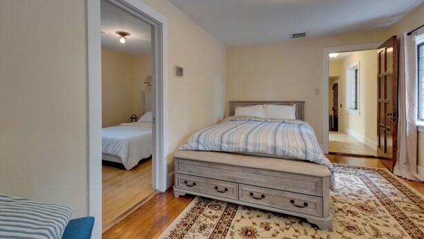 A bedroom with a bed, a nightstand, a dresser, and a walk-in closet. - Luxury Tudor Estate | Pool, Spa and Valley Views (Hazleton)