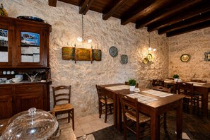 Ein rustikales Interieur mit Holzmöbeln, Steinwänden und verzierten Tellern.