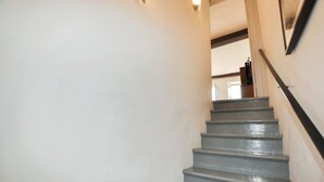 A staircase with a handrail, leading to an interior space with a door at the top. - Newly renovated three-story 16th-century house in central Ceret (Céret)