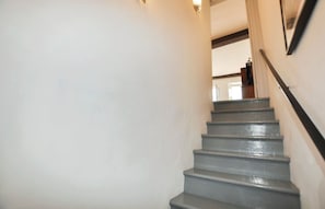 Eine Treppe mit Handlauf, die zu einem Innenraum mit einer Tür führt.