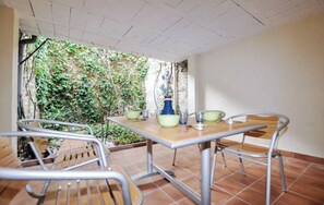 Eine Terrasse im Freien mit Tisch und Stühlen, umgeben von einem Garten.