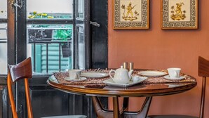A dining area with a round table, two chairs, and a window with a view. - Le stanze al genio di Darlon (Palermo)