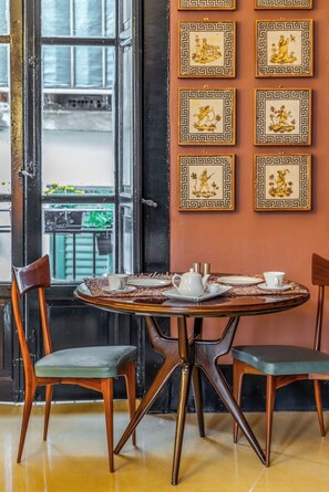 Un comedor con una mesa redonda, dos sillas y una ventana con vistas.