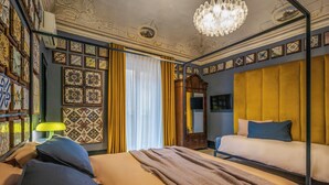 A room with a bed, a mirror, a chandelier, and patterned walls. - Le stanze al genio di Darlon (Palermo)