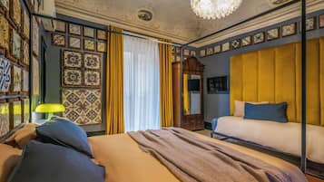A room with a bed, a mirror, a chandelier, and patterned walls.