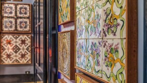 Una pared con baldosas de diversos diseños, algunas con motivos geométricos y otras con diseños florales.