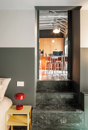 Una escalera que lleva a una zona de cocina con una mesa y sillas.