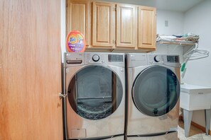 A laundry area with two front-loading washers, wooden cabinets above, and a white sink to the right. - Private Deck & Hot Tub! Family Sanctuary in Frisco (Frisco)