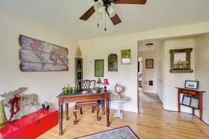 A room with a wooden floor, a red dresser, a globe on a table, and a ceiling fan. - Welcome to Buck's Hideout in Bridgton Maine! (Bridgton)