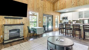 Un intérieur en bois avec une cheminée, un coin repas et une cuisine.
