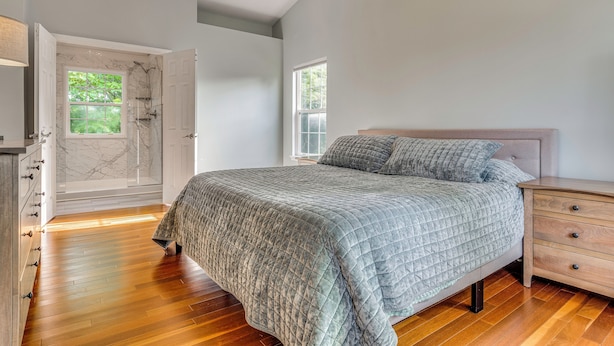 A bedroom with a bed, a nightstand, a dresser, a walk-in closet, a ceiling fan, and a window. - Treehouse Views! Walking Distance to IMS (Indianapolis)