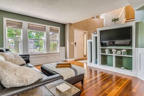 A living room with a fireplace, a sofa, and a television. - Treehouse Views! Walking Distance to IMS (Indianapolis)
